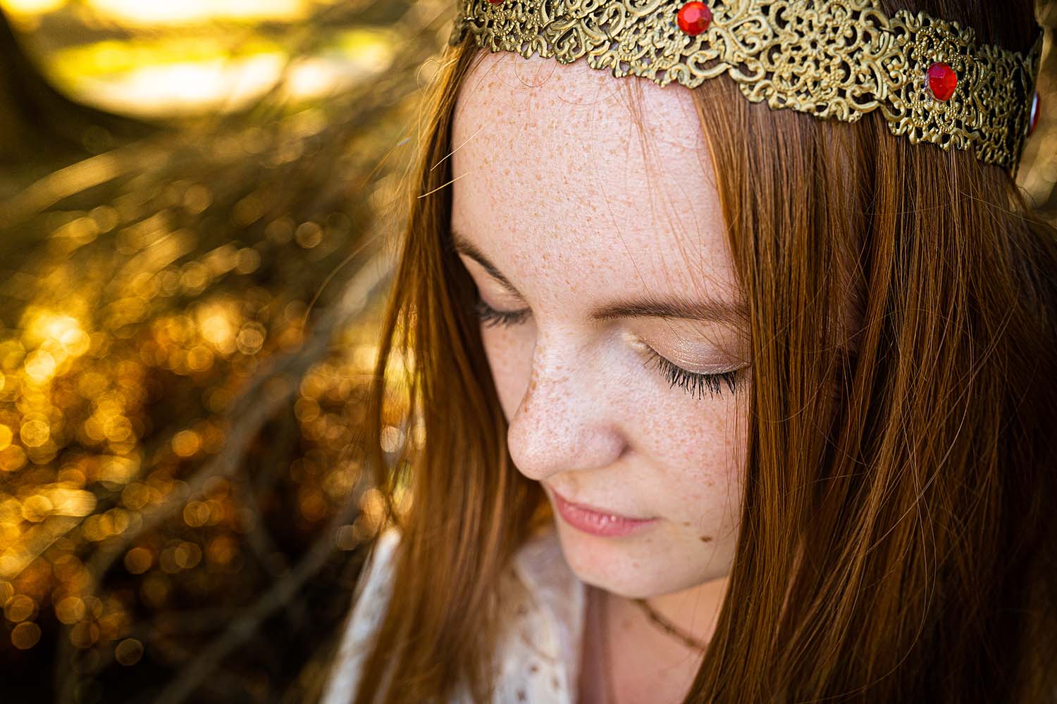 portrait artistique en couleur d'une jeune femme rousse avec une couronne dorée avec des gemmes rouges